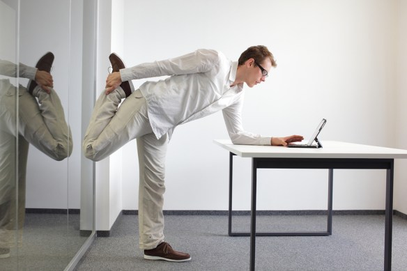 leg exercise at office work - standing man reading at tablet